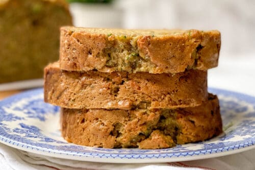 Slices of Zucchini Bread stacked on a blue and white plate