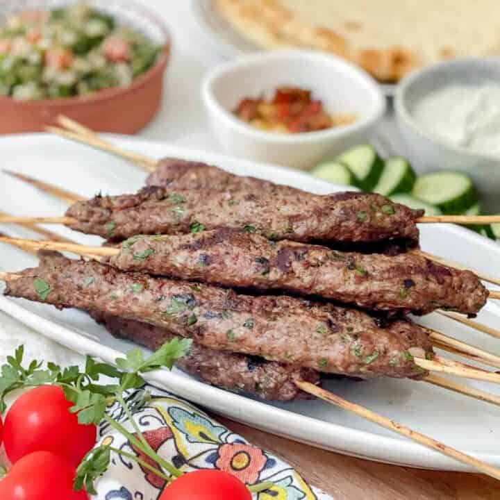 Side view of Beef Kofta Kebabs on a white platter