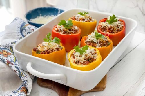 Side view of baked Stuffed Peppers in a white casserole dish