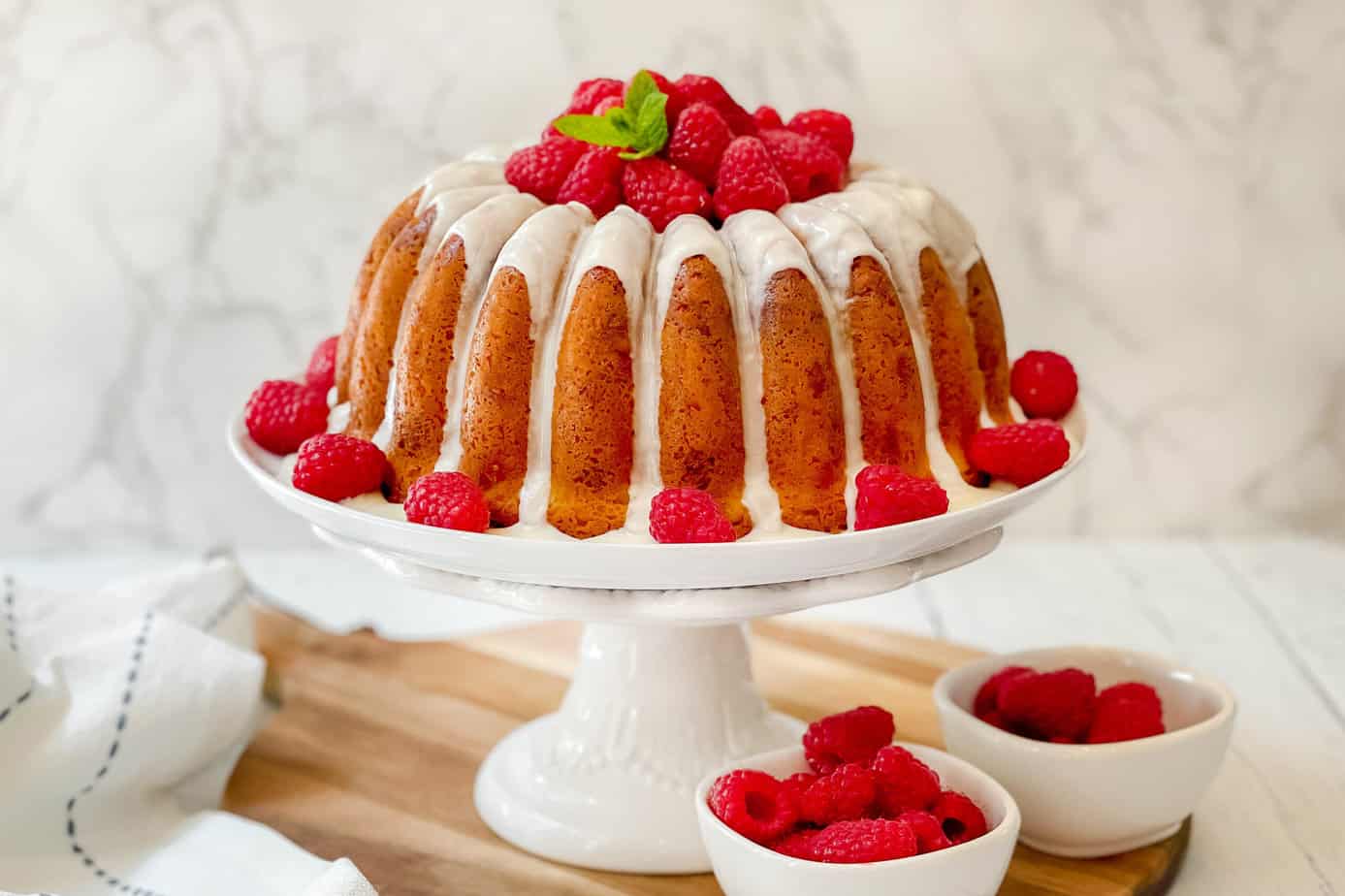Closeup view of White Chocolate Raspberry Cake on a stand