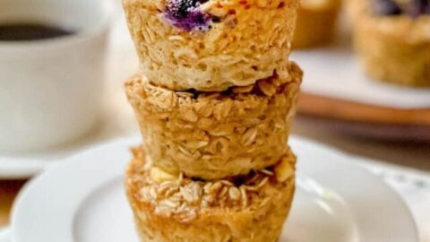 Stack of 3 Baked Oatmeal Cups on a white plate with more in the background