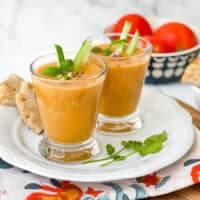 Side view of 2 glasses of Gazpacho with cucumbers, red onions and tomatoes