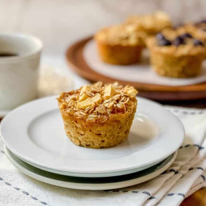 Top view of Apple Baked Oatmeal Cup on a white plate with coffee