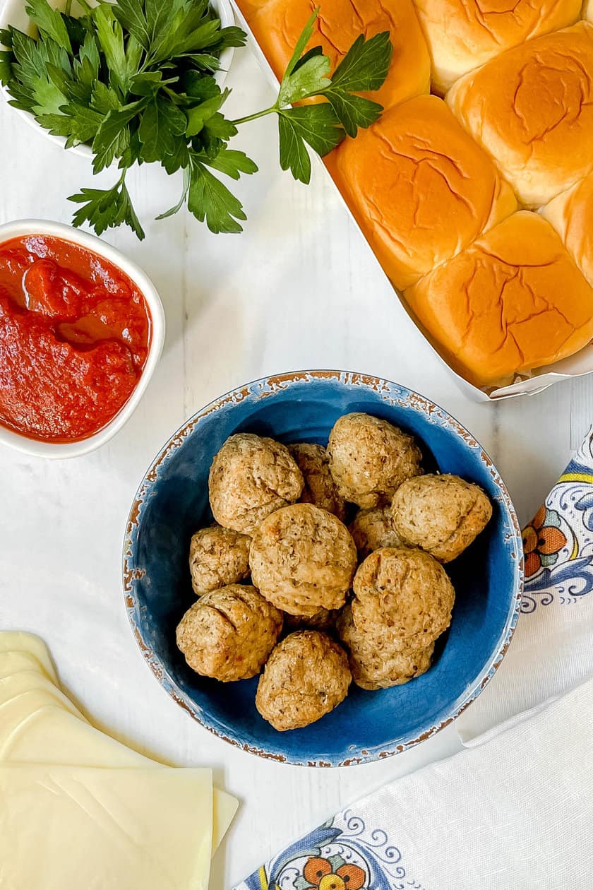 Top view of ingredients for Meatball Sliders on parchment paper