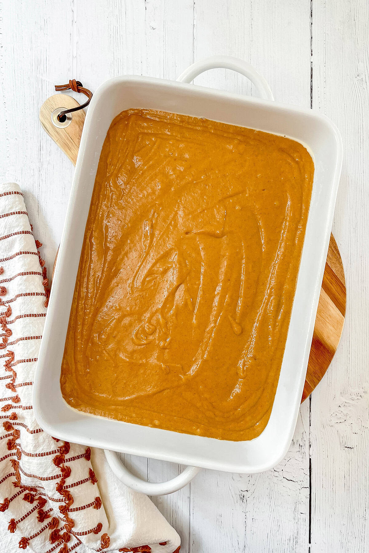Mixing pumpkin bar batter and transferring to a 9 x 13 inch baking pan.