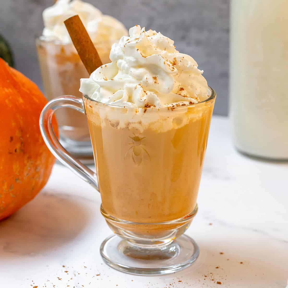 Creamy homemade pumpkin spice latte topped with whipped cream and warm pumpkin pie spice.