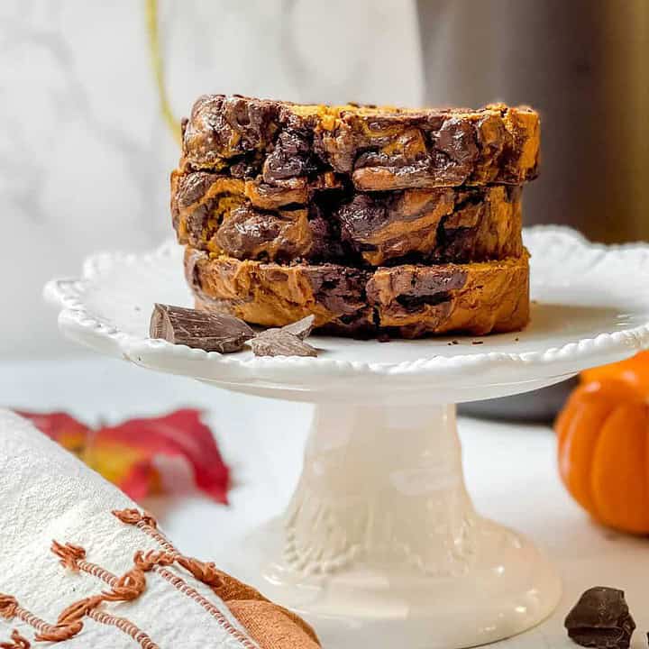 Chocolate Swirl Pumpkin Bread stacked on a white scalloped cake plate