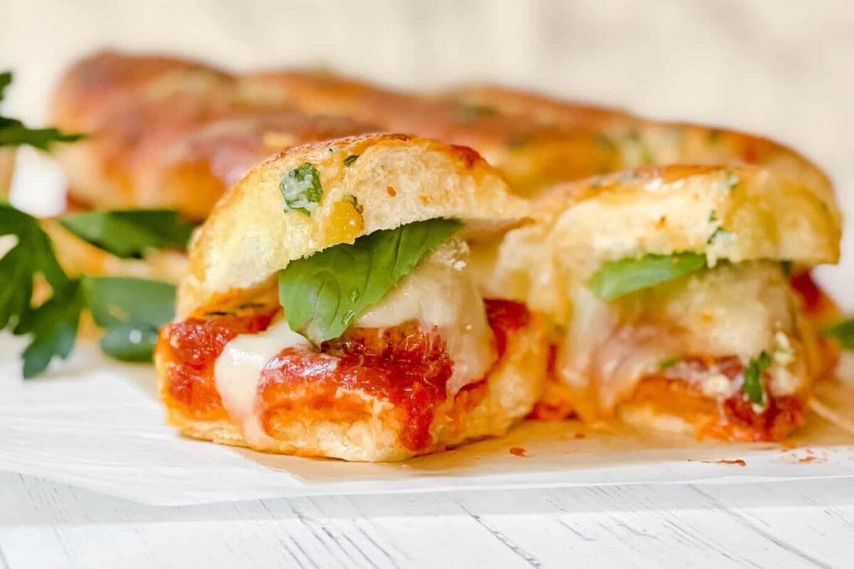 Closeup view of Meatball Hawaiian Roll Slider with basil, marinara and melting mozzarella cheese