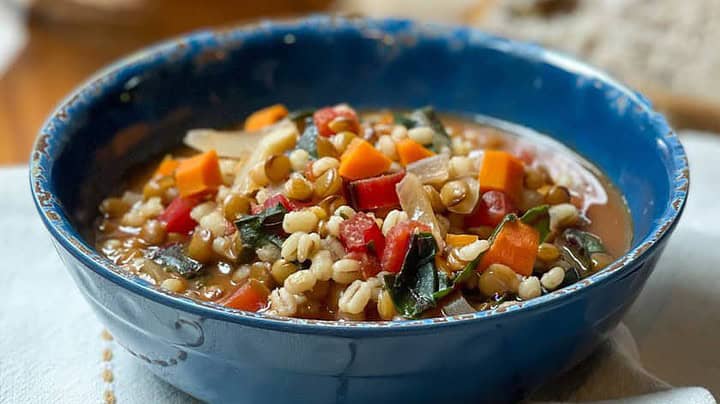 Side view of Lentil Barley Soup in a blue distressed bowl.