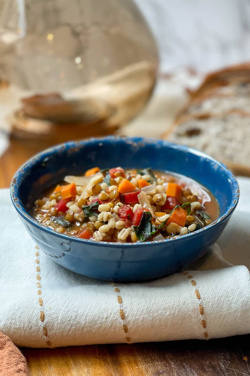 Side view of Lentil Barley Soup in a blue distressed bowl.