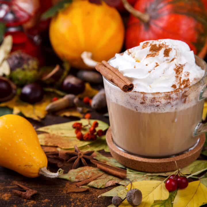 Side view of Cinnamon Dolce Latte in a glass mug with cinnamon stick