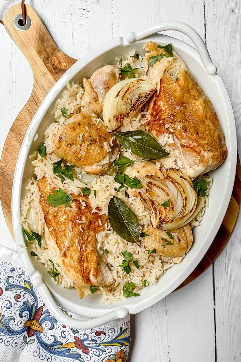 Top view of Chicken and Rice Casserole with fresh bay leaves and caramelized onions