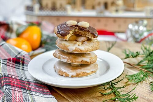 Side view of stacked Lebkuchen on a white plate with a bite missing