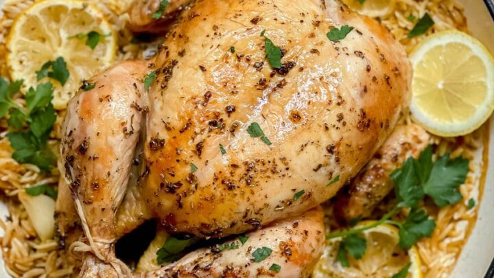 Closeup top view of Greek Roasted Chicken with Lemon Orzo in braising pan