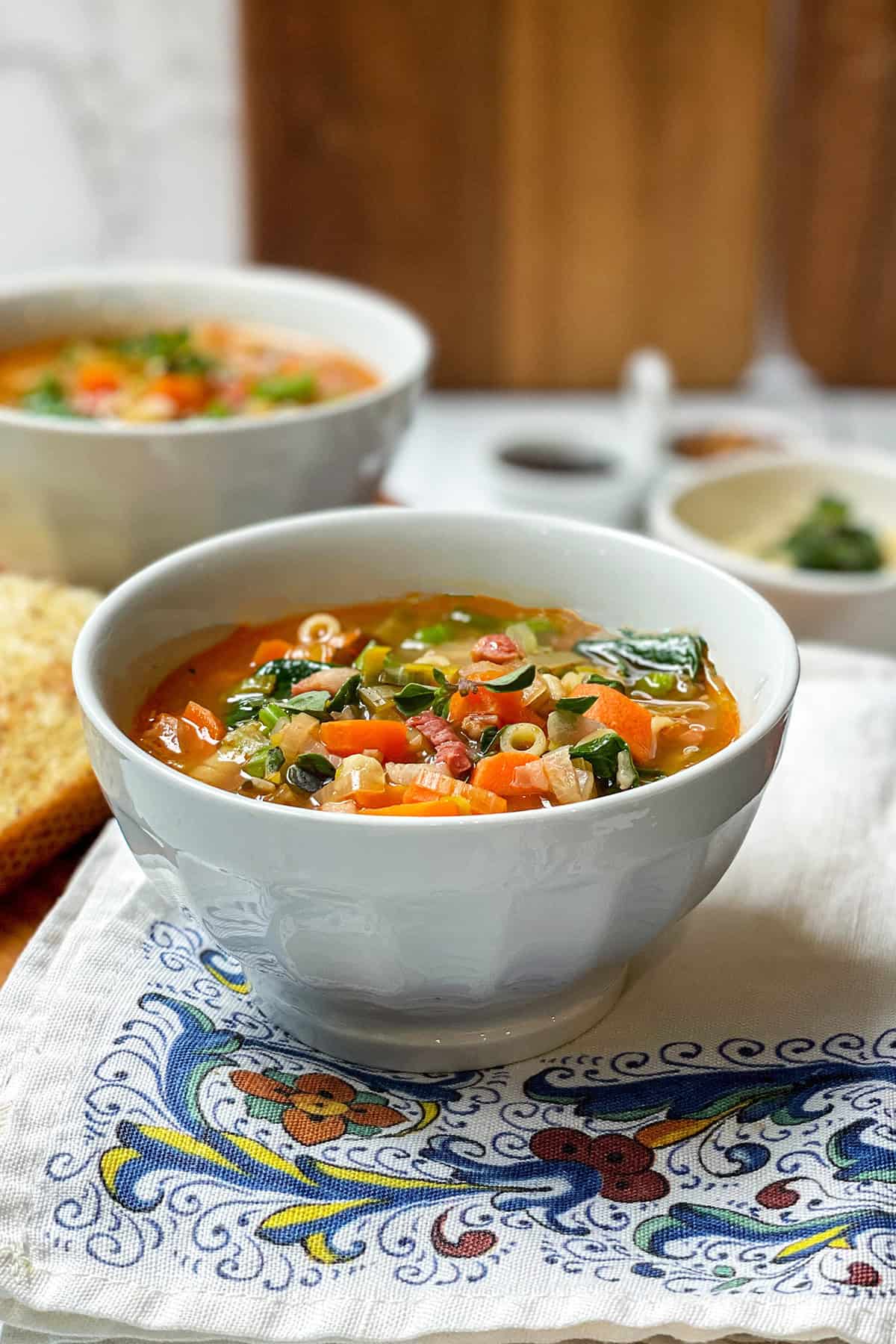 Bowl of Italian Minestrone Soup with Crispy Pancetta in a bowl with hearty toasted bread alongside.