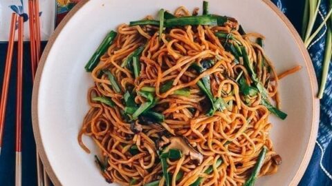Top view of long life noodles in a white and gold bowl for Chinese New Year celebrations.