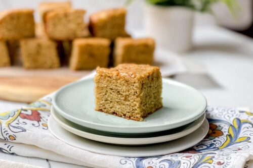 Serving of Maple Banana Snack Cake on a teal colored plate with more servings in the background