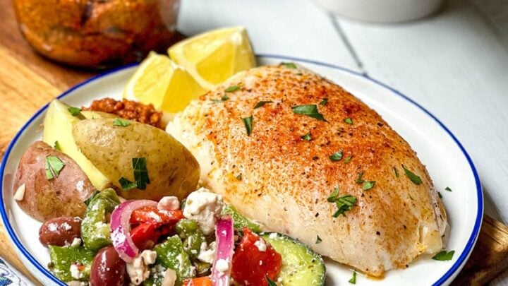 Side view of Spanish Baked Cod recipe with Mediterranean Salad and potatoes