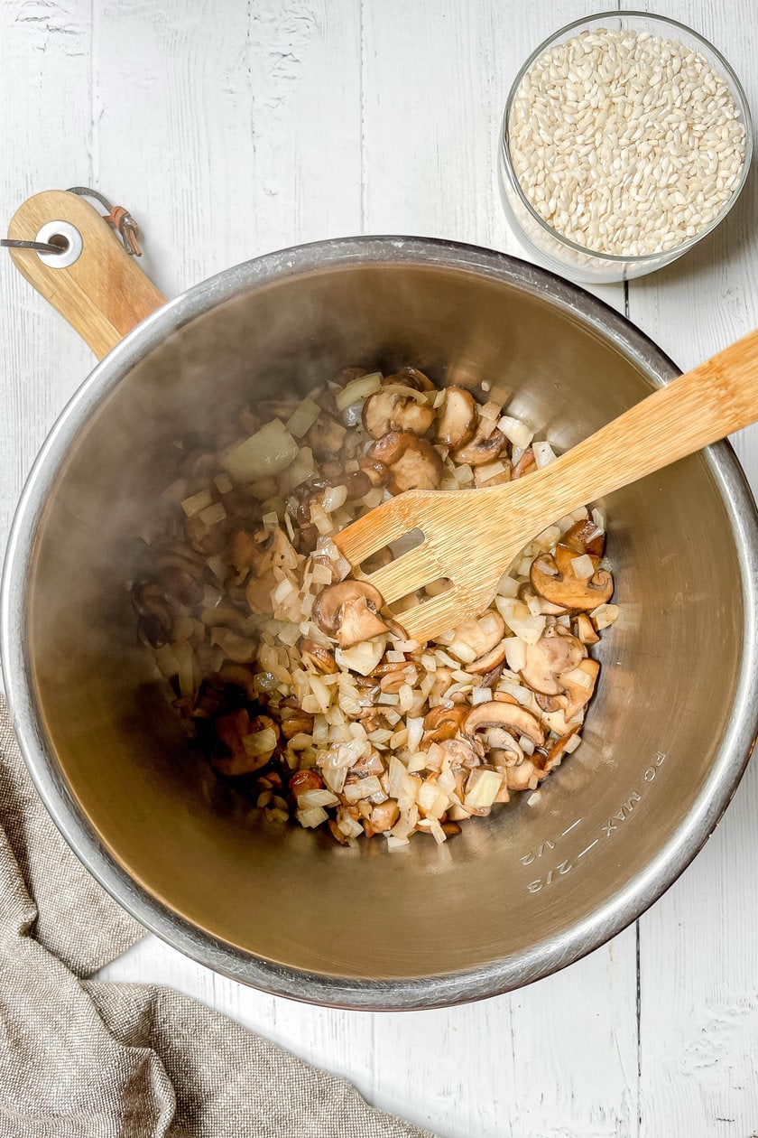 Top view of mushrooms and onions sauteing in olive oil