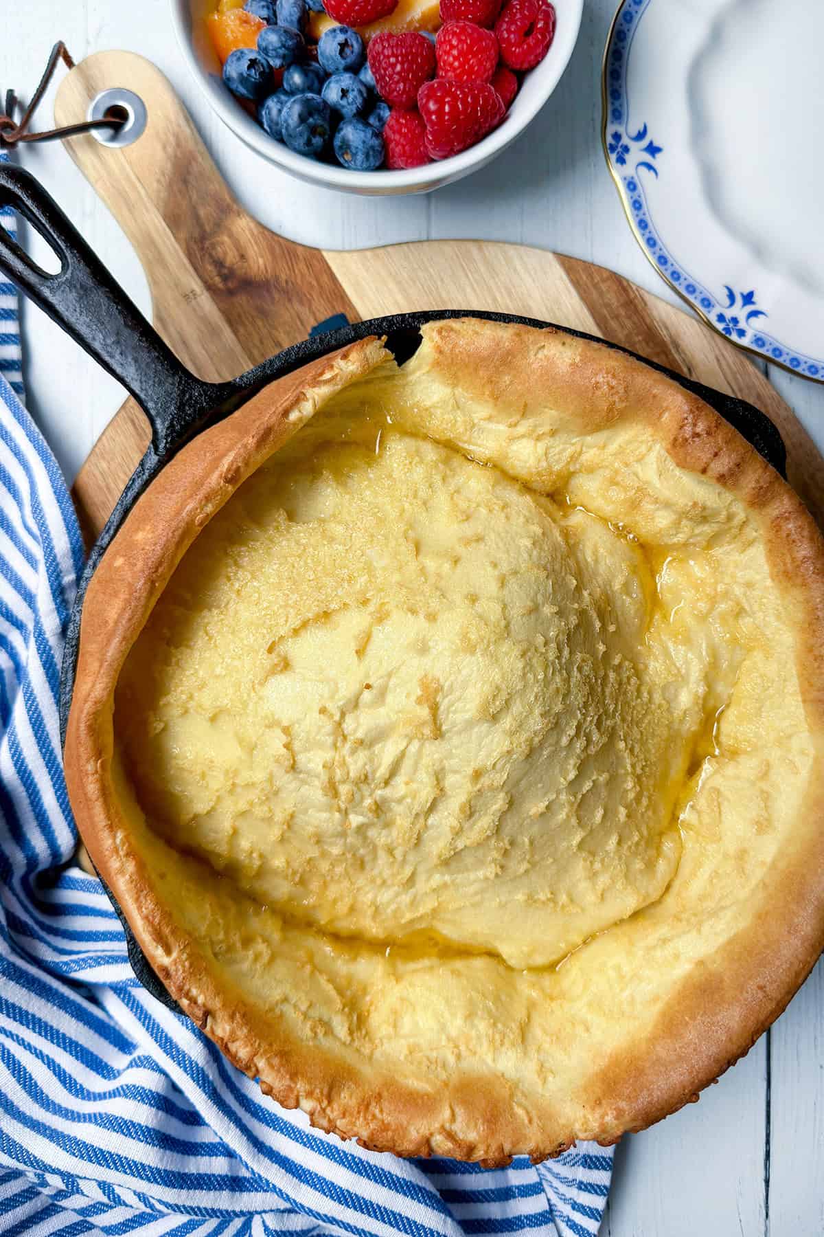 Freshly baked and puffed from the oven, a German pancake in a cast iron skillet ready for toppings.