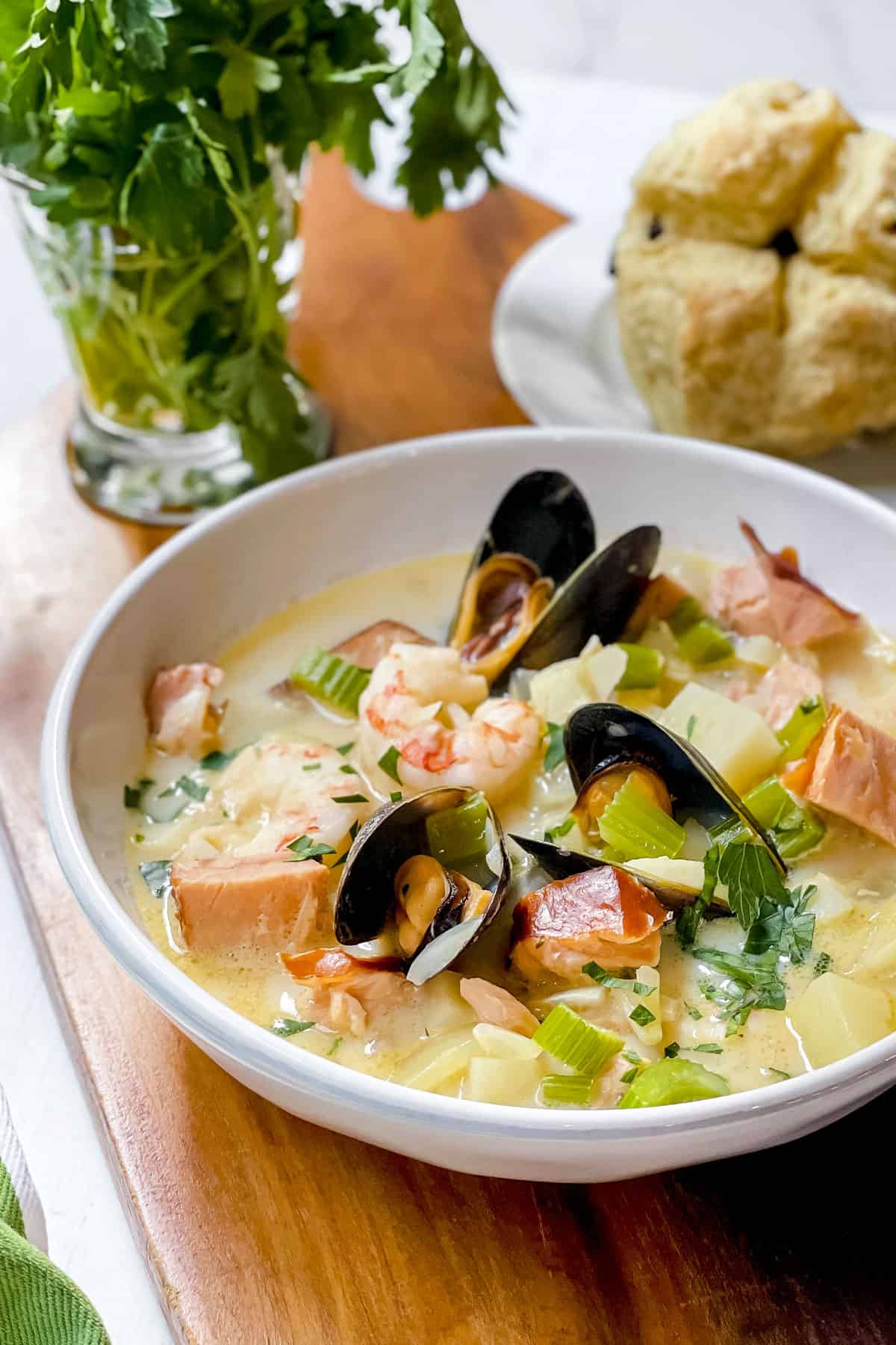 Bowl of Seafood Chowder in a white bowl with Mini Irish Soda Breads in the background.