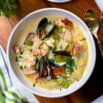 Irish Seafood Chowder in a white bowl with shrimp, smoked salmon and mussels garnishing the top.