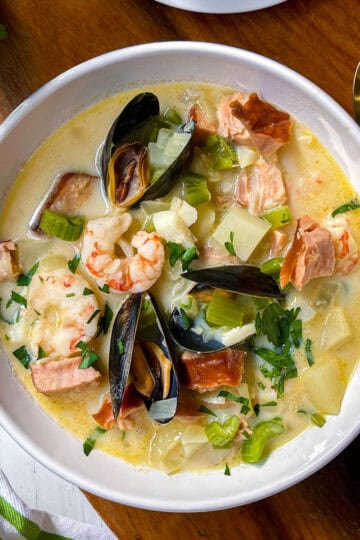Irish Seafood Chowder in a white bowl with shrimp, smoked salmon and mussels garnishing the top.