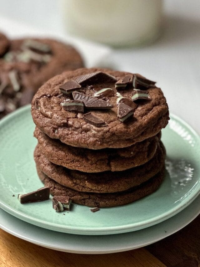 Stack of Chocolate Mint Cookies on a green plate with chopped Andes mints.