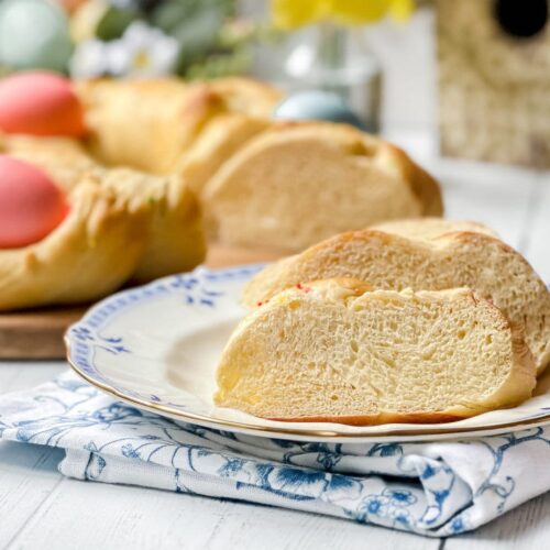 Side view of Italian Easter Bread, sliced, on a blue and white plate.
