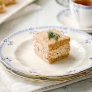 Closeup view of Salmon Salad Tea Sandwich on wheat bread with a sprig of dill