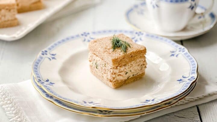 Closeup view of Salmon Salad Tea Sandwich on wheat bread with a sprig of dill