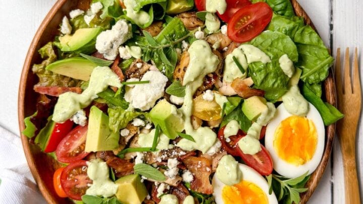 Top view of Chicken Cobb Salad in a wooden bowl with a wooden fork for serving