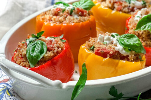 Side view of Crockpot Stuffed Peppers with Quinoa in a serving dish in front of a window