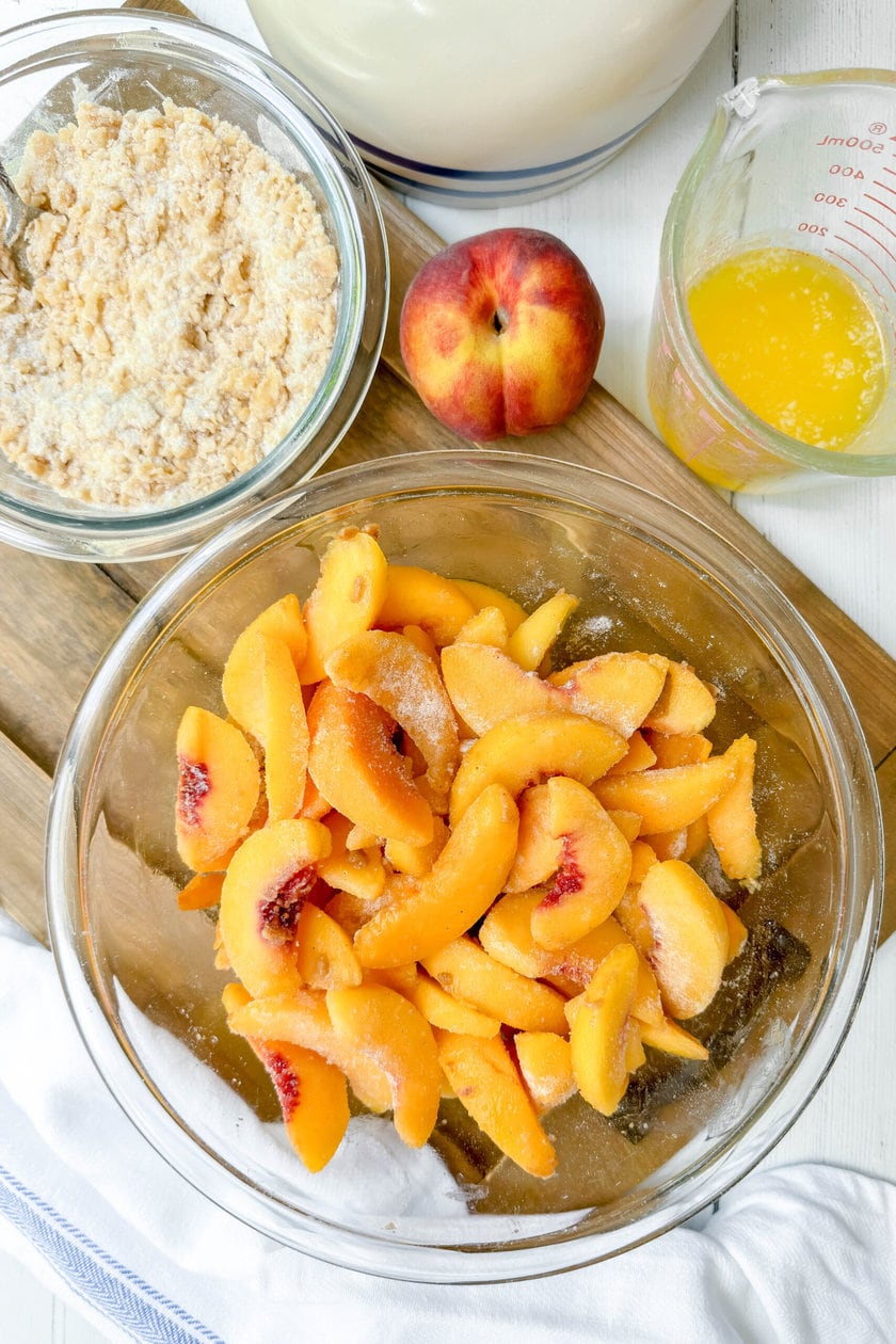 Top view of peach crumble ingredients on a wood serving board