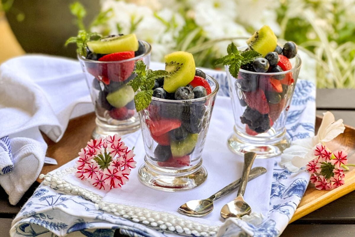 Side view of 3 glasses filled with Fruit Salad and garnished with fresh mint