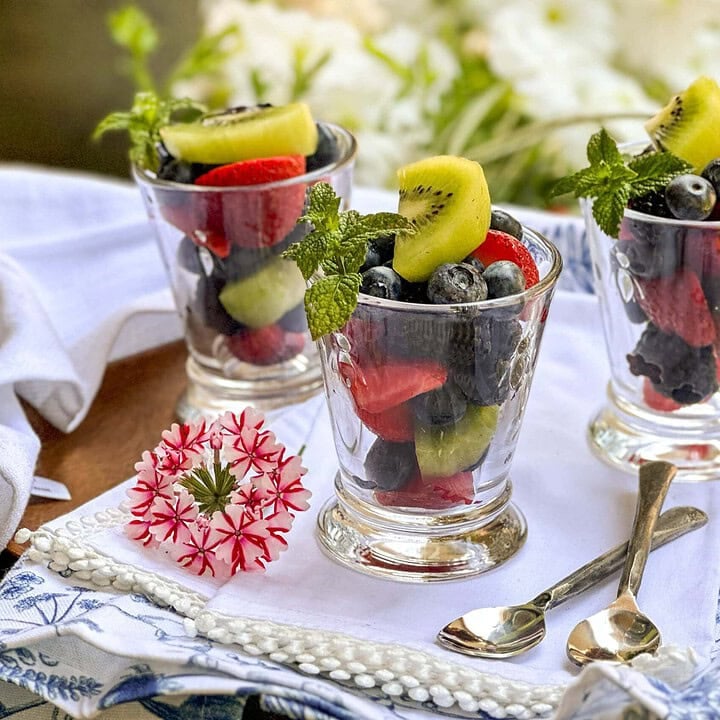 Side view of 3 glasses filled with Fruit Salad and garnished with fresh mint