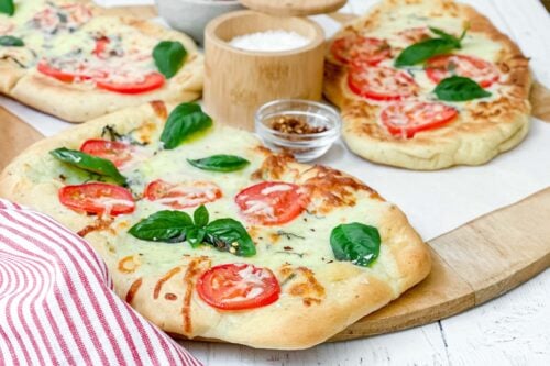 Side view of grilled flatbread with tomatoes, basil and mozzarella