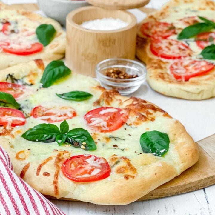 Side view of grilled flatbread with tomatoes, basil and mozzarella