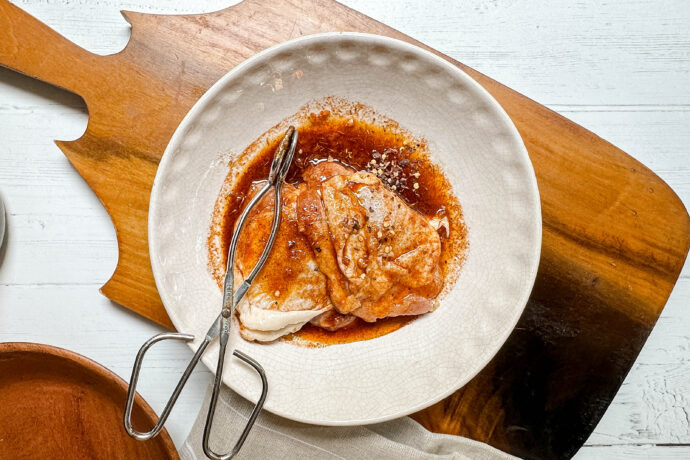 Top view of uncooked chicken thighs in paprika sauce
