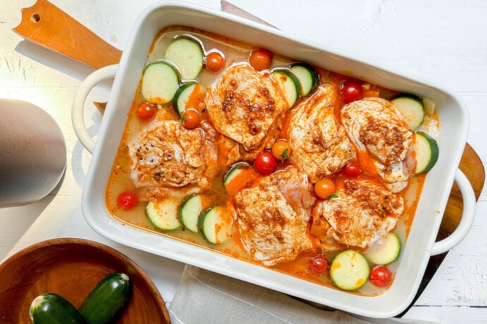 Top view of Chicken and Rice with zucchini and tomatoes in a casserole dish ready for the oven