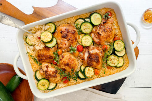 Top view of One Pan Chicken and Rice with a silver fork in a white casserole dish