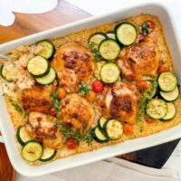 Top view of One Pan Chicken and Rice with a silver fork in a white casserole dish