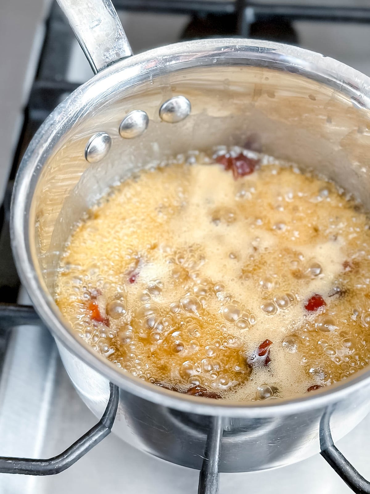 Date mixture simmering in a saucepan for Rice Bubble Slice