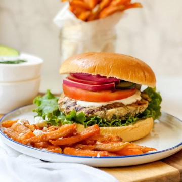 Greek turkey burger with feta and herbs served on a bun with fresh toppings.