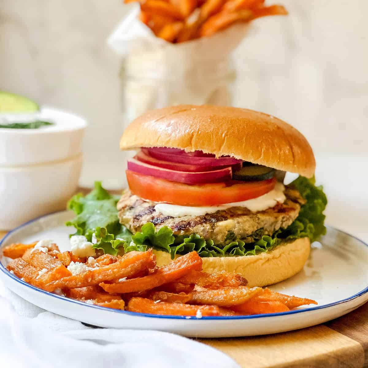 Greek turkey burger with feta and herbs served on a bun with fresh toppings.