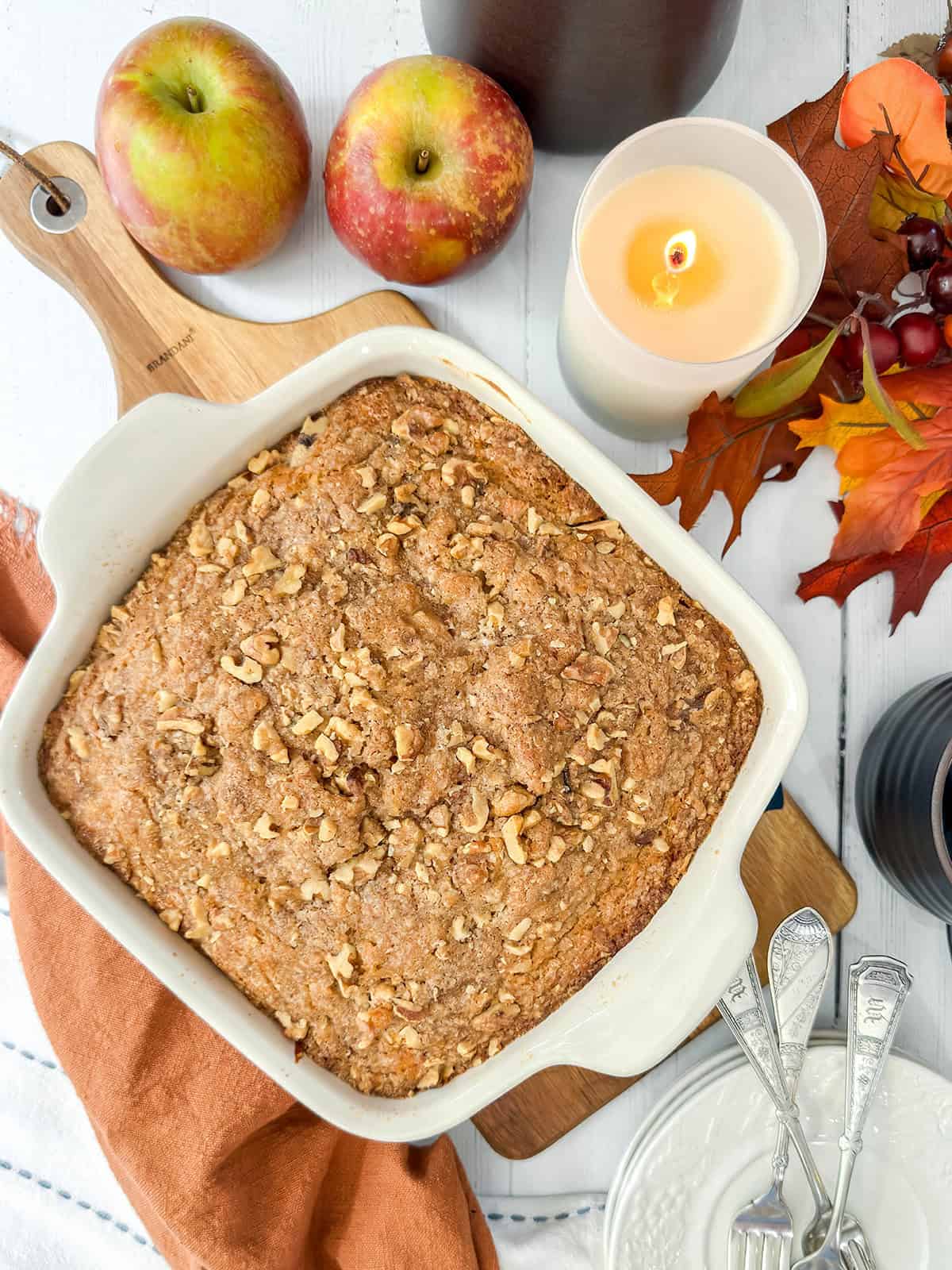 Baked apple coffee cake in a square pan ready for serving and drizzling with caramel sauce.