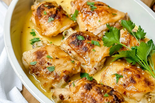 Side view of Slow Cooker Chicken Thighs in a white oval casserole dish