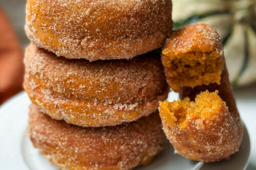 Closeup side view of pumpkin donuts with a bite missing