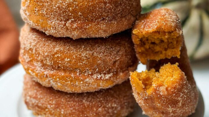Closeup side view of pumpkin donuts with a bite missing