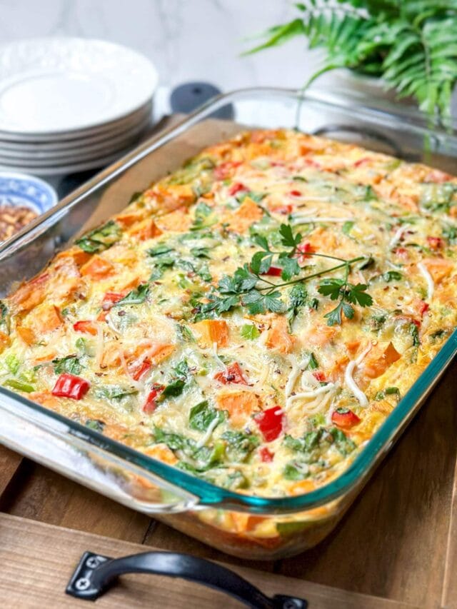 Side view of just baked Sweet Potato Casserole in a glass casserole dish and topped with fresh parsley